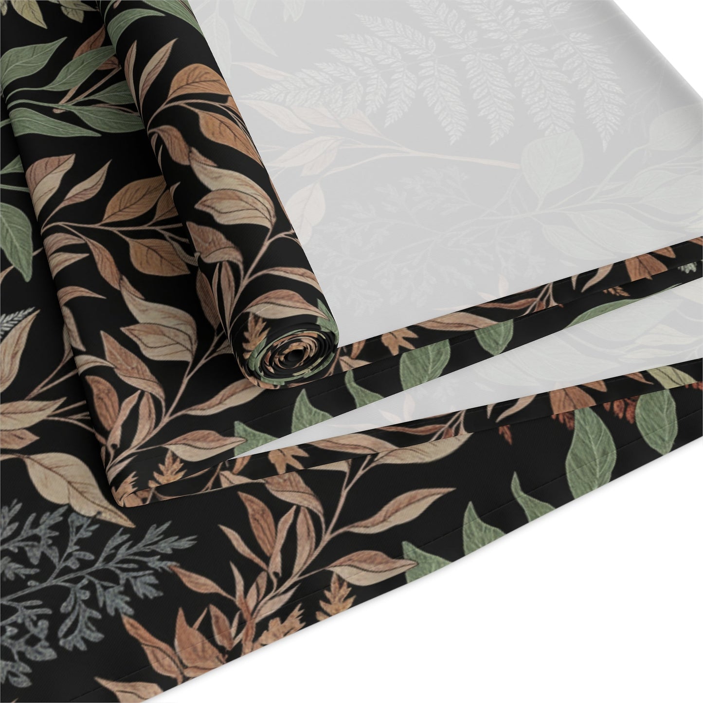 Close up of botanical leaf table runner showing hemmed edge and fabric texture.
