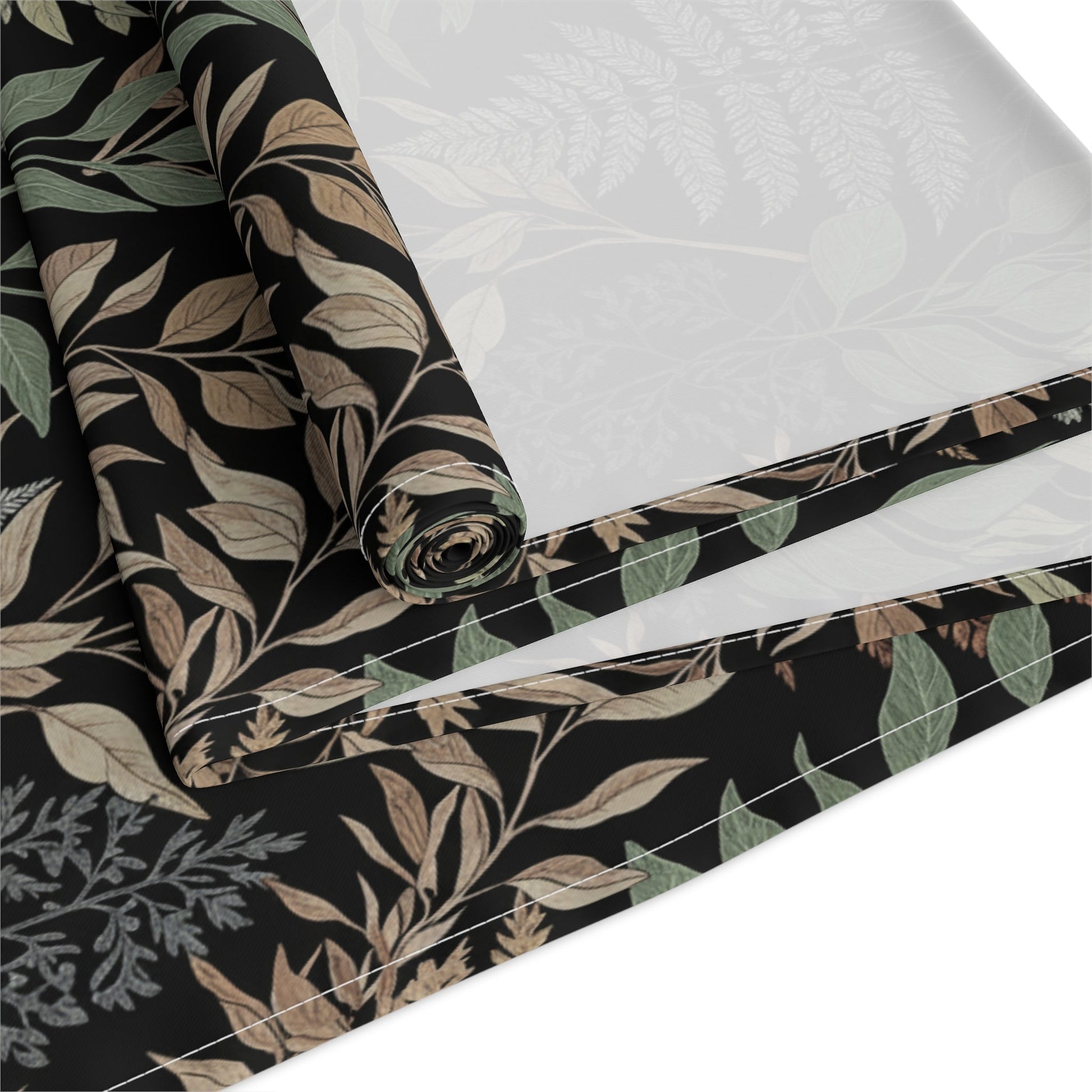 Detailed view of botanical fern table runner fabric with folded edge showing leaf pattern. Cotton Twill